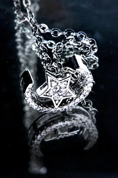 Commercial — star pendant on black mirror